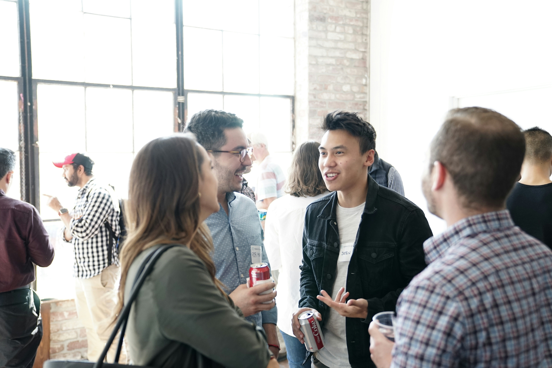 A group of professionals talking together at a networking event — building referral relationships rooted in shared faith and accountability.